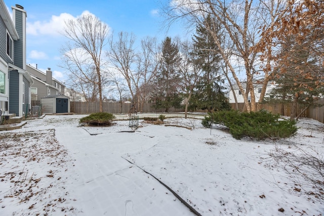 yard layered in snow featuring a shed