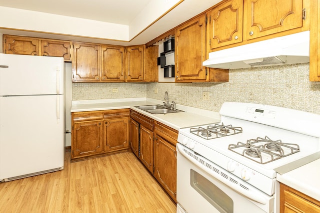 kitchen featuring decorative backsplash, sink, light hardwood / wood-style floors, and white appliances