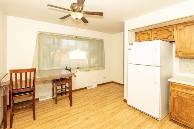 kitchen featuring ceiling fan, white refrigerator, and light hardwood / wood-style floors