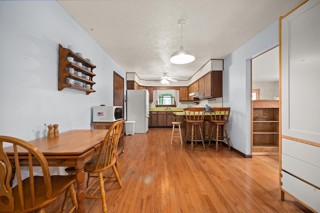 dining area with ceiling fan and light hardwood / wood-style flooring