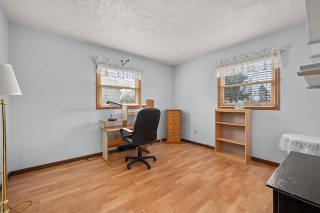 home office featuring a textured ceiling and light hardwood / wood-style flooring