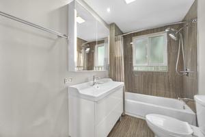 full bathroom featuring wood-type flooring, vanity, toilet, and tiled shower / bath combo