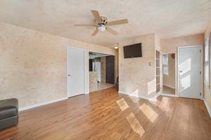 unfurnished living room with hardwood / wood-style flooring and ceiling fan