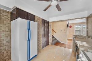 kitchen with white refrigerator, dark brown cabinetry, and ceiling fan