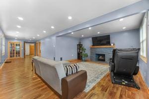 living room with a fireplace and light wood-type flooring