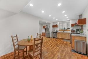 dining space featuring light wood-type flooring and sink