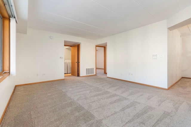 carpeted empty room with washer and dryer