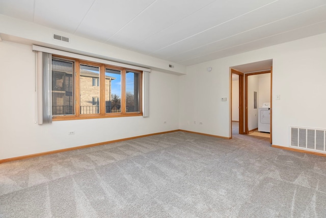 unfurnished room with carpet floors and washer / dryer