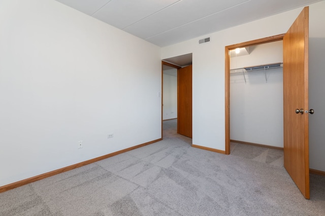 unfurnished bedroom with a closet and light carpet