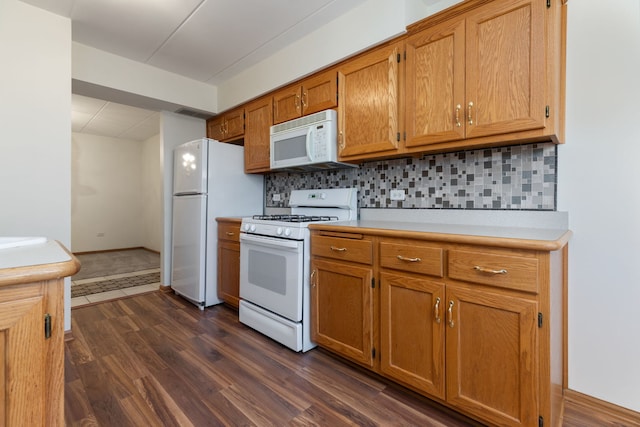 kitchen featuring backsplash, white appliances, and dark hardwood / wood-style floors