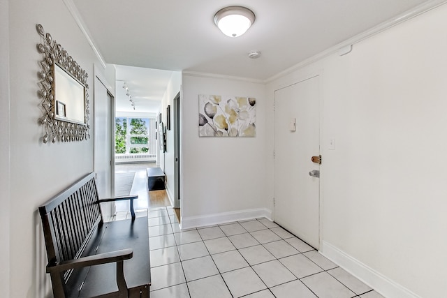 hall featuring light tile patterned floors, crown molding, and track lighting