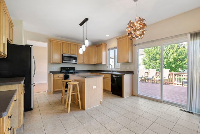 kitchen with a center island, black appliances, a kitchen breakfast bar, hanging light fixtures, and light tile patterned floors