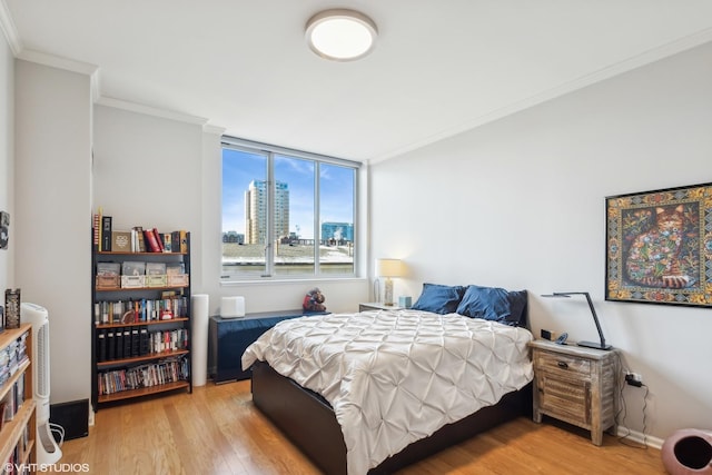 bedroom with light hardwood / wood-style floors and crown molding