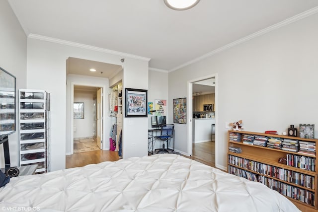 bedroom featuring ornamental molding, light hardwood / wood-style flooring, and ensuite bath