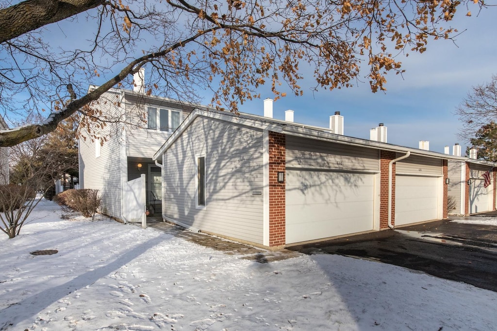 view of snowy exterior with a garage