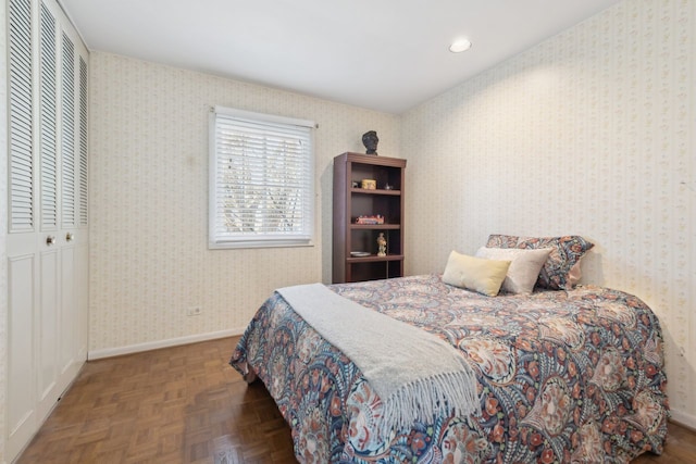 bedroom with dark parquet floors and a closet