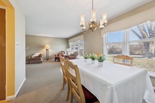 carpeted dining space with a chandelier