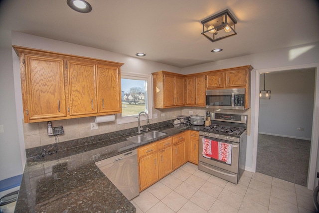 kitchen with light tile patterned floors, backsplash, sink, and stainless steel appliances