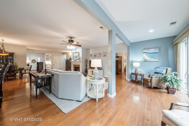 kitchen with pendant lighting, a breakfast bar, a kitchen island with sink, light hardwood / wood-style flooring, and stainless steel appliances