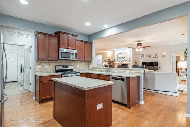 kitchen with sink, hanging light fixtures, stainless steel dishwasher, ceiling fan, and light hardwood / wood-style floors