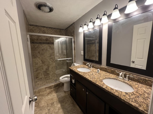 bathroom featuring vanity, toilet, and a shower with shower door