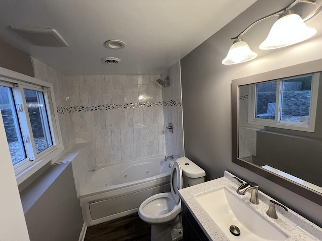 full bathroom featuring vanity, hardwood / wood-style flooring, toilet, and shower / bathtub combination