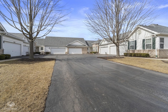 exterior space with brick siding, roof with shingles, and community garages