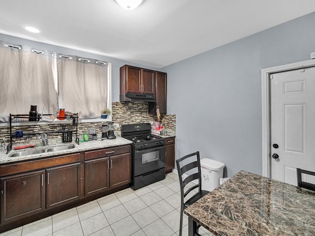 kitchen featuring light tile patterned flooring, backsplash, sink, gas stove, and light stone counters