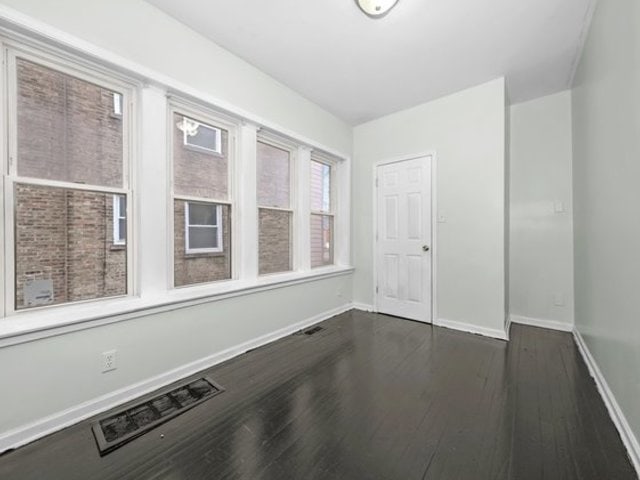 spare room featuring dark wood-type flooring