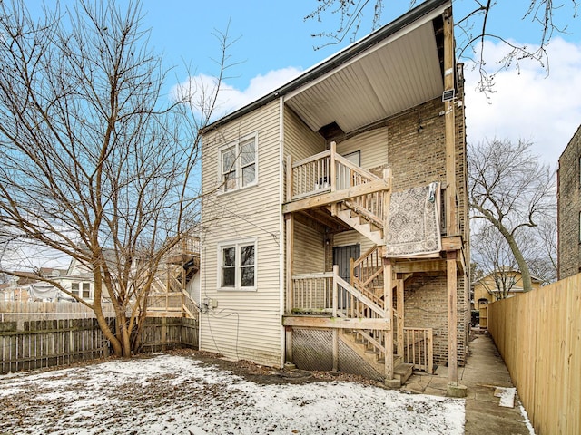 snow covered property with a balcony