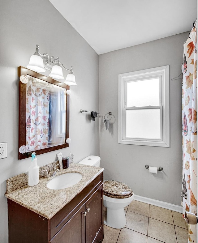 bathroom with toilet, vanity, and tile patterned floors