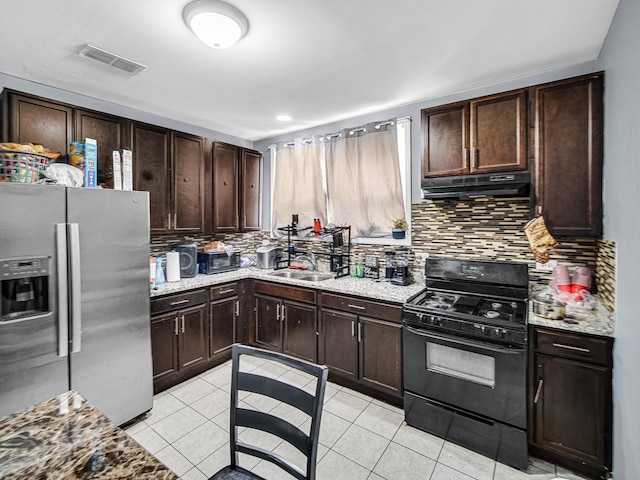 kitchen with black gas stove, sink, decorative backsplash, light tile patterned floors, and stainless steel fridge with ice dispenser