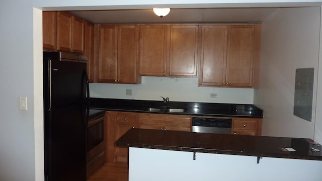 kitchen with dishwasher, sink, kitchen peninsula, stove, and black refrigerator