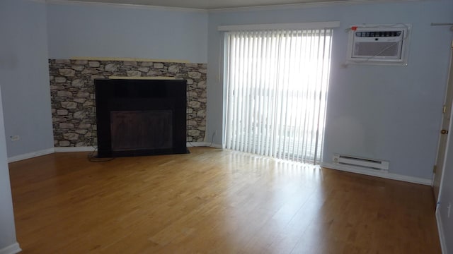 unfurnished living room featuring an AC wall unit, hardwood / wood-style flooring, ornamental molding, a fireplace, and a baseboard radiator