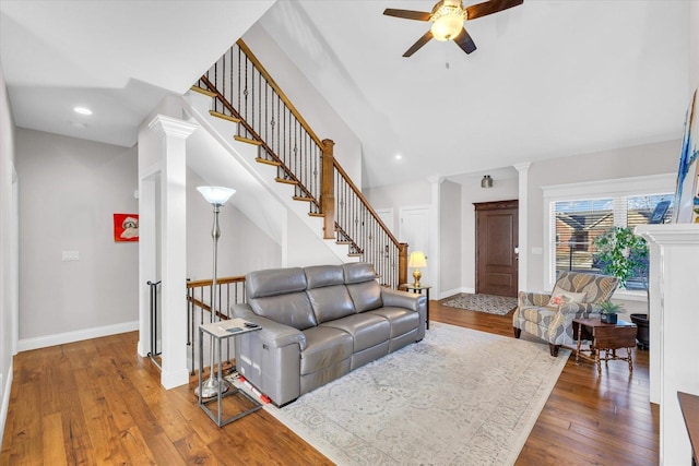 living room featuring ceiling fan, decorative columns, and hardwood / wood-style flooring