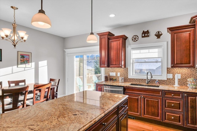 kitchen with sink, decorative light fixtures, an inviting chandelier, and tasteful backsplash