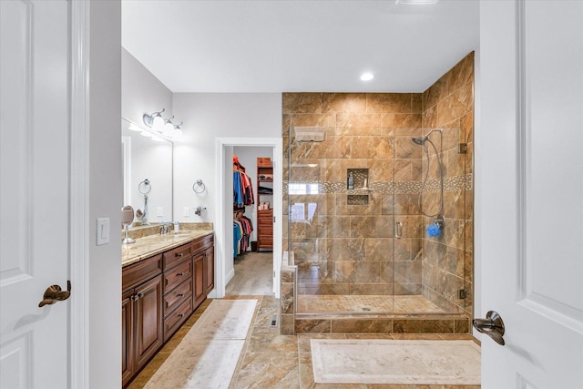 bathroom featuring tiled shower and vanity