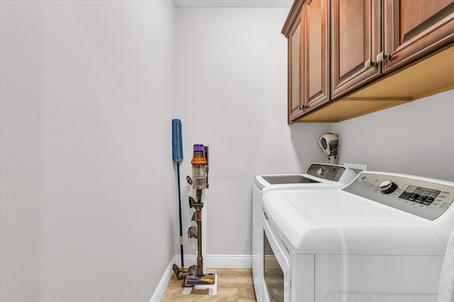 washroom with washing machine and dryer and cabinets