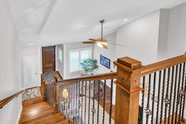 stairs featuring ceiling fan, lofted ceiling, ornate columns, and hardwood / wood-style flooring