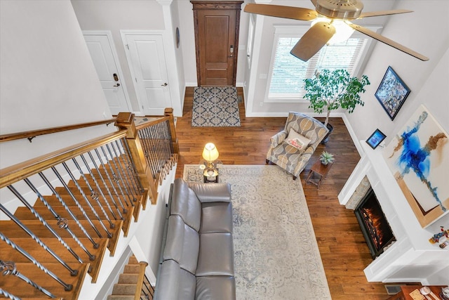 living room featuring decorative columns, ceiling fan, and hardwood / wood-style floors