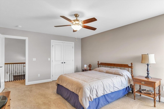 carpeted bedroom with ceiling fan and a closet