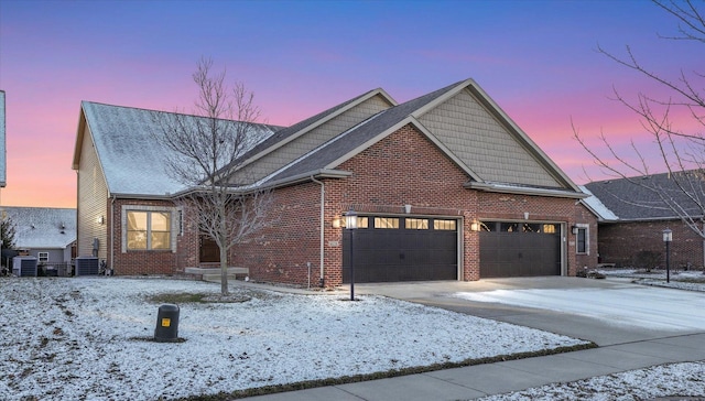 view of front of home featuring central air condition unit and a garage