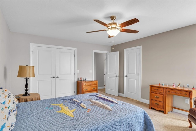 carpeted bedroom with ceiling fan and a closet