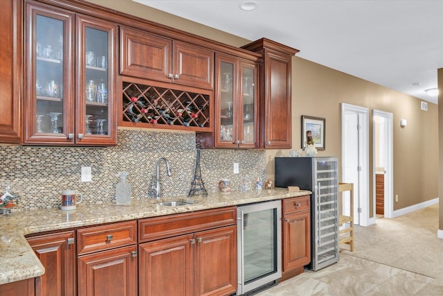 kitchen featuring sink, decorative backsplash, wine cooler, and light stone countertops