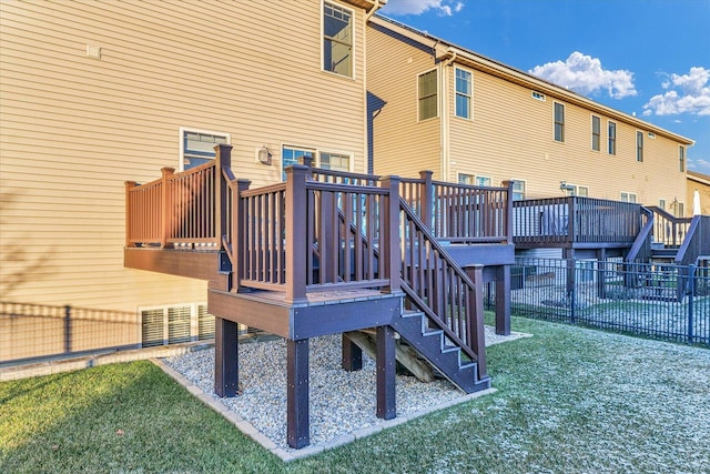 rear view of house with a lawn and a wooden deck