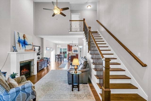 living room with a high ceiling, dark wood-type flooring, and ceiling fan