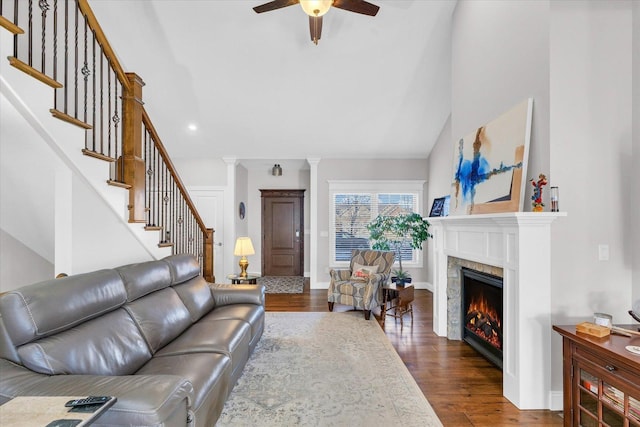 living room featuring ceiling fan, hardwood / wood-style floors, and decorative columns