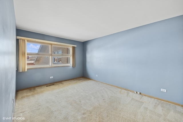 spare room featuring light colored carpet