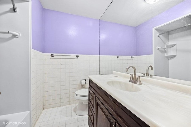 bathroom with tile patterned floors, vanity, a shower, tile walls, and toilet