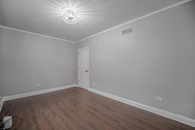 empty room featuring ornamental molding and dark wood-type flooring